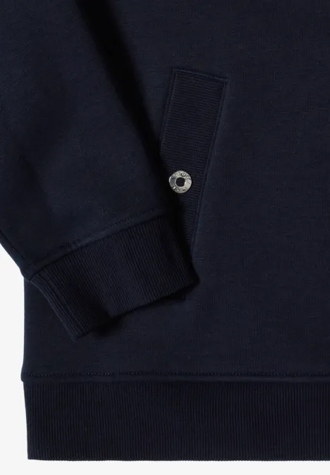 Nahaufnahme eines dunkelblauen Sweatshirts mit geripptem Ärmelbündchen, Eingrifftasche und silbernem Druckknopf.