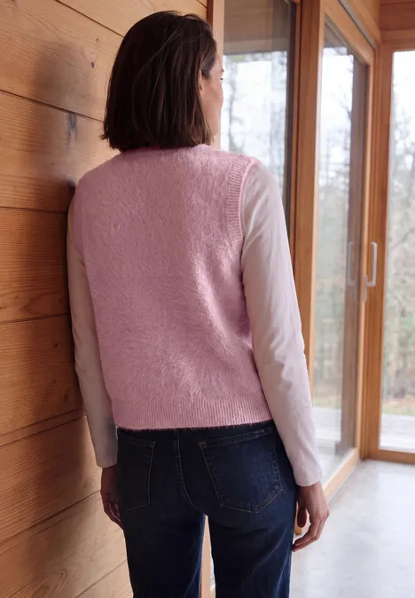 Open vest van veergaren in effen kleur velvet rose Frau steht mit dem Rücken zur Kamera, trägt rosafarbenen Fleece-Weste, Langarmshirt und Jeans in Holzhaus.