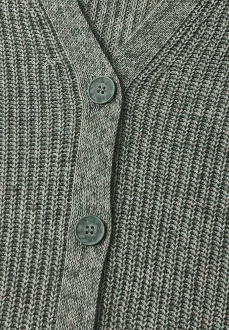Gros plan d’un gilet en maille côtelée gris-vert avec trois boutons ronds assortis.