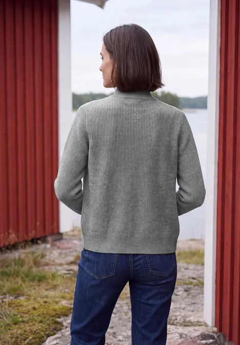 Cardigan mit Stehkragen und Zipper sporty grey melange Eine Frau in grauem Pullover und Jeans steht mit dem Rücken zur Kamera vor einem See zwischen roten Holzhäusern