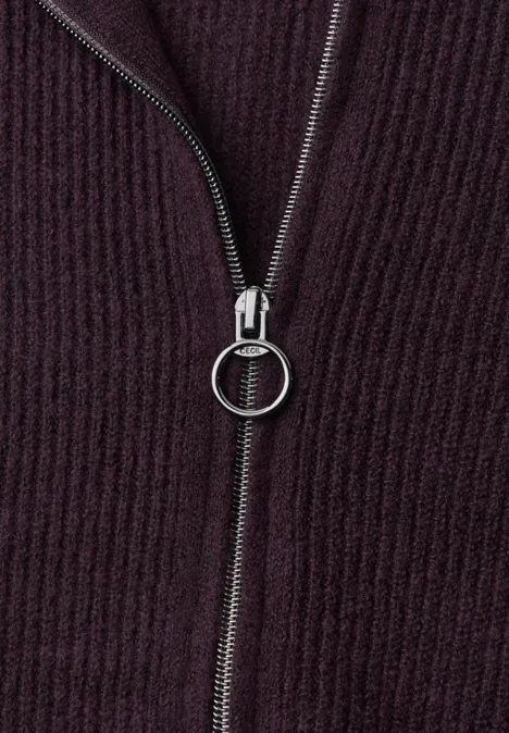 Tricot côtelé violet foncé avec fermeture éclair argentée et tirette ronde.