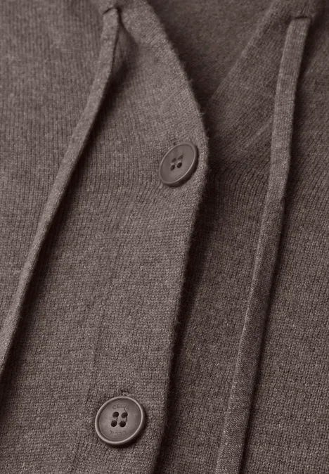 Close-up van een grijsbruine gebreide cardigan met knopen en koord