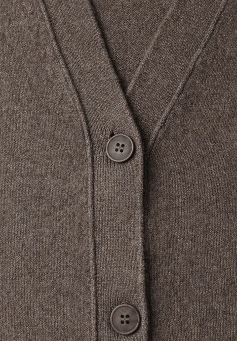 Nahaufnahme eines braunen Strickcardigans mit V-Ausschnitt und zwei großen Knöpfen.