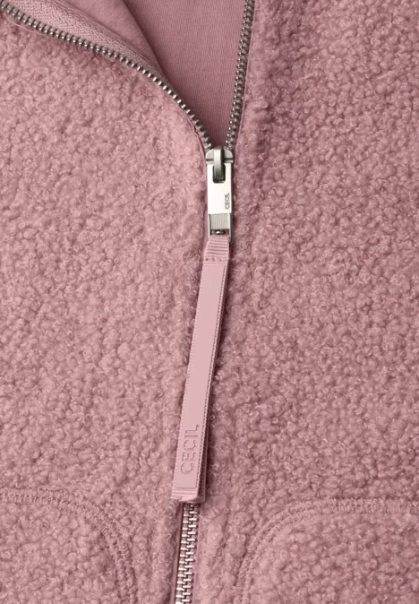 Nahaufnahme einer rosa Teddy-Fleecejacke mit silbernem Reißverschluss und Zipperzug.