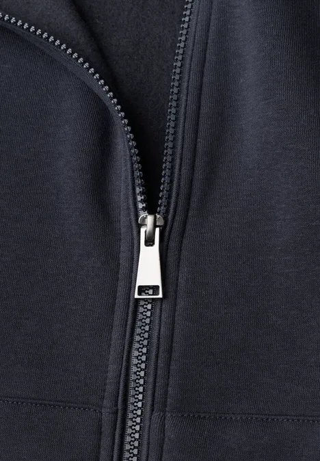 Langarm Sweatjacke mit Kapuze urban dark blue Nahaufnahme eines hellen Metallreißverschlusses an einem dunklen Stoff.