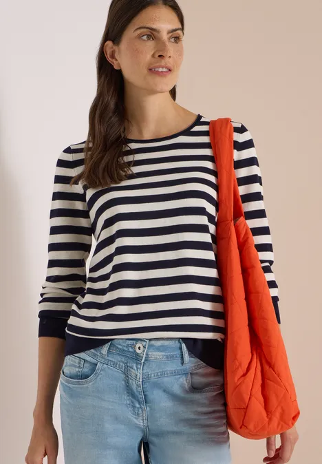 Trui met ronde hals en strepen urban dark blue Vrouw met gestreept shirt, lichte spijkerbroek en oranje tas voor neutrale achtergrond.