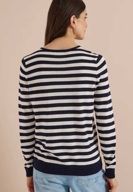 Trui met ronde hals en strepen urban dark blue Vrouw van achteren in een marineblauw-wit gestreepte trui met lange mouwen en een spijkerbroek.