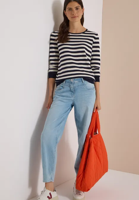 Trui met ronde hals en strepen urban dark blue Vrouw in gestreept shirt en lichtblauwe spijkerbroek, met een grote oranje tas.