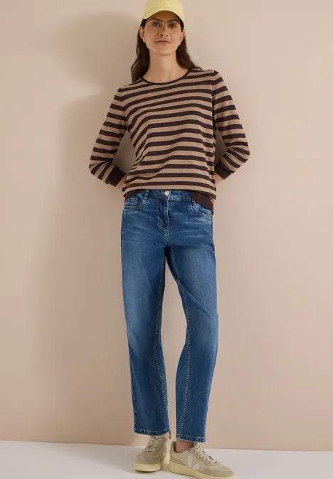 Trui met ronde hals en strepen truffle brown Vrouw in gestreepte trui, spijkerbroek, sneakers en gele pet voor een neutrale achtergrond.