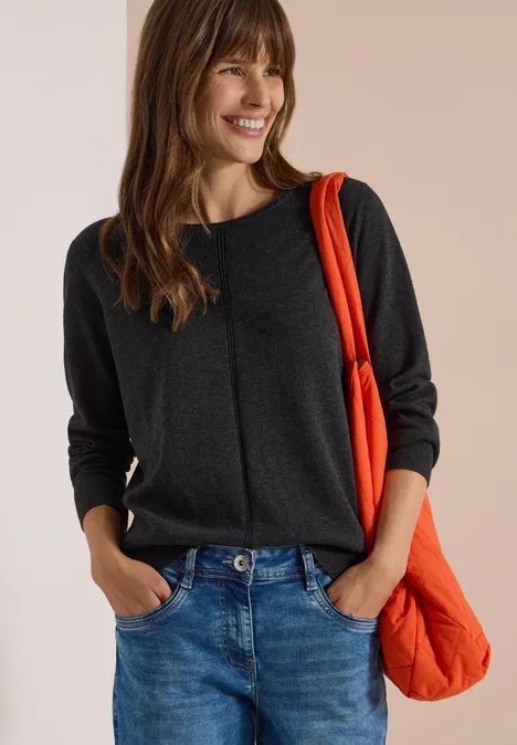 Basic Pullover mit Rundhals in Unifarbe charcoal grey melange Frau in grauem Pullover und Jeans trägt lächelnd eine orangefarbene Schultertasche