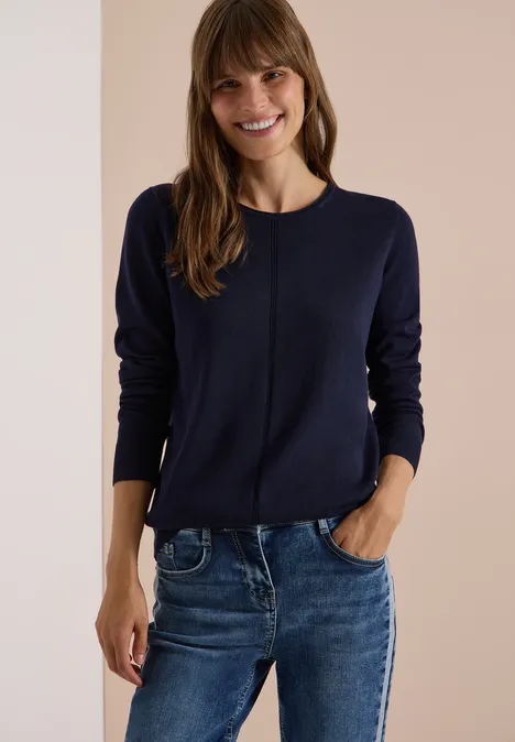 Basic Pullover mit Rundhals in Unifarbe urban dark blue Eine lächelnde Frau trägt einen dunkelblauen Pullover und Jeans.