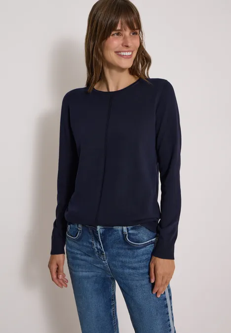 Basic Pullover mit Rundhals in Unifarbe urban dark blue Frau in dunkelblauem Pullover und Jeans steht lächelnd vor hellem Hintergrund.