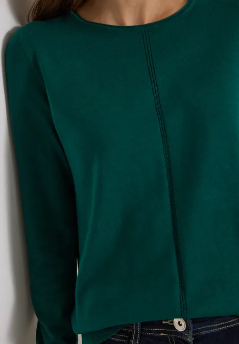 Basic Pullover mit Rundhals in Unifarbe dark fir green Nahaufnahme eines dunkelgrünen Pullovers mit Nahtdetail und blauer Jeans.
