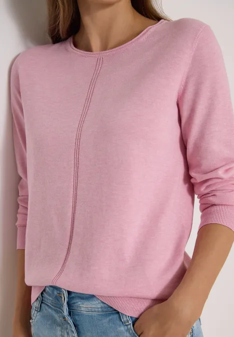 Rosa Damenpullover mit langen Ärmeln und subtiler Mittelnaht, kombiniert mit blauen Jeans