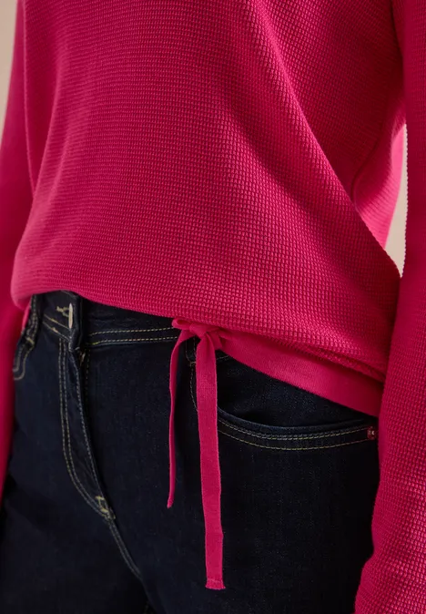 Pullover mit Rundhals und Struktur pink flash Pinkfarbener Pullover mit seitlicher Schlaufenbindung und langen Ärmeln, kombiniert mit dunkler Jeans.