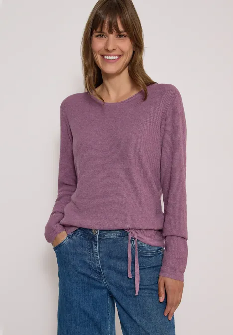 Pullover mit Rundhals und Struktur lavender purple melange Eine lächelnde Frau in lila Pullover und blauer Jeans steht vor hellem Hintergrund.