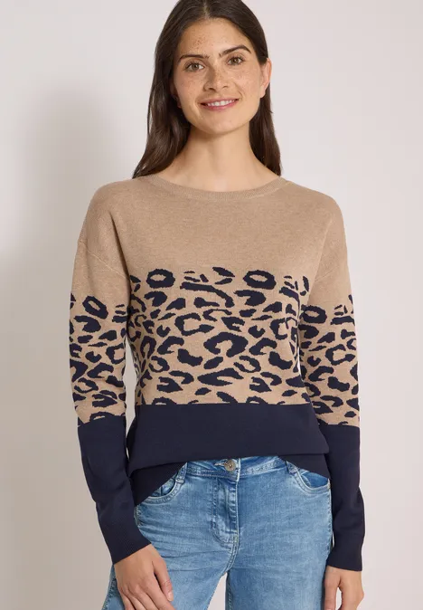 Langarm Pullover mit Leo-Jacquard-Muster urban dark blue Frau trägt beigen Pullover mit Leopardenmuster und blaue Jeans
