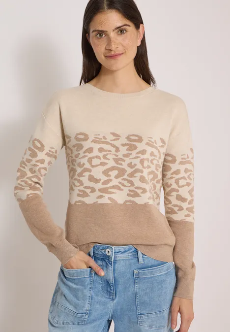 Langarm Pullover mit Leo-Jacquard-Muster creamy mocha melange Frau in beigem Pullover mit Leopardenmuster und blauer Jeans.