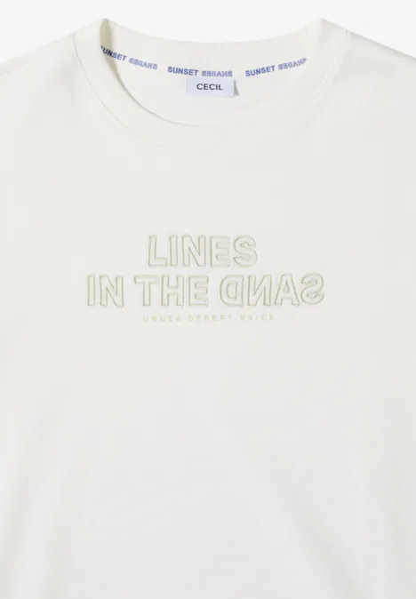 Wit T-shirt met lichte opdruk 'LINES IN THE SAND' op de borst.