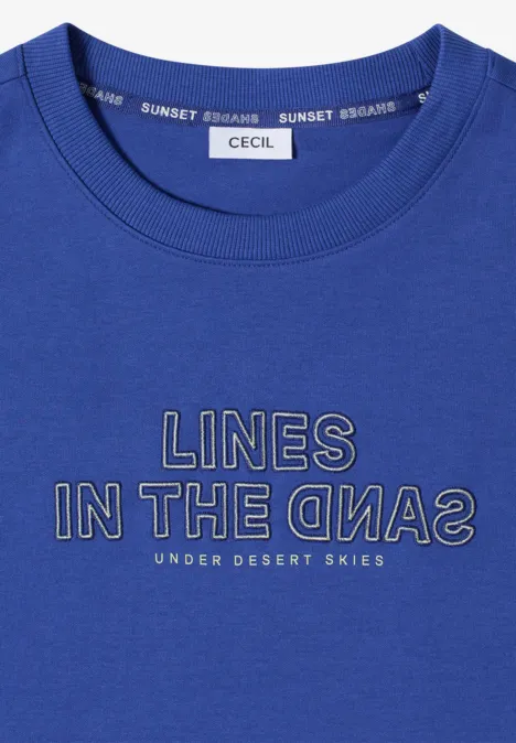 Blauw T-shirt met ronde hals en opdruk ‘LINES IN THE SANDS – UNDER DESERT SKIES’.
