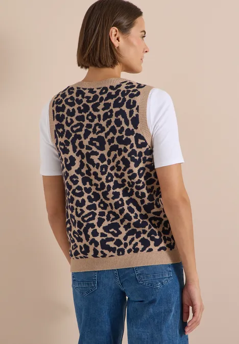 Rückenansicht einer Frau in leo-bedrucktem Pullunder und Jeans
