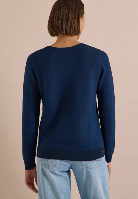 Pull bicolore à col en V urban dark blue Personne de dos portant un pull bleu et un jean