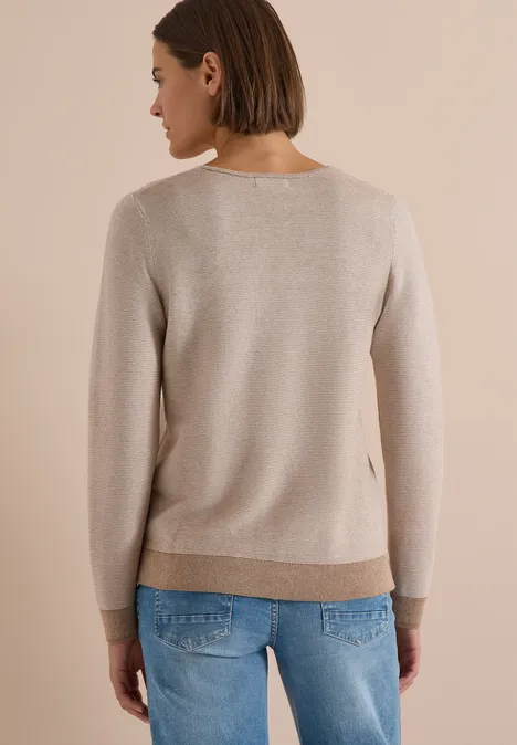 Pull bicolore à col en V creamy mocha melange Vue de dos d'une femme en pull beige clair et jean bleu.