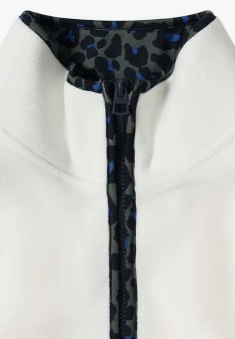 Nahaufnahme eines weißen Reißverschluss-Oberteils mit dunkelblau-schwarzem Camouflage-Futter am Kragen.