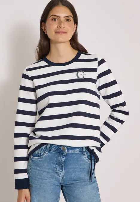 Sweatshirt mit Rundhals und Tunnelzug urban dark blue Frau trägt weiß-blau gestreiftes Langarmshirt mit kleinem Herz-Detail, kombiniert mit Jeans.