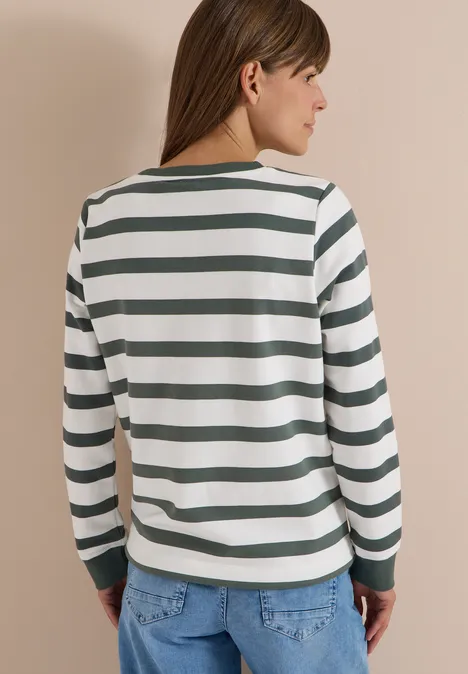 Rückenansicht einer Person im weiß-grün gestreiften Langarmshirt und Jeanshose.