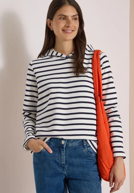 Sweatshirt mit Kapuze und Streifen vanilla white Junge Frau in gestreiftem Shirt und Jeans mit oranger Tasche lächelt vor hellem Hintergrund