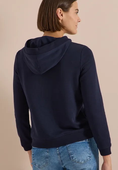 Sweatshirt mit Kapuze und Wording urban dark blue Rückansicht einer Frau mit kurzem Haar, sie trägt einen dunkelblauen Kapuzenpullover.