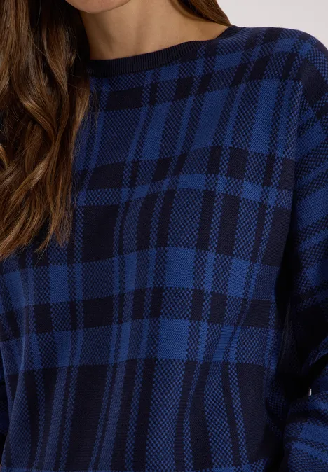 Sweter z rękawem typu dolman w kratkę urban dark blue Kobieta w niebiesko-czarnym, kratkowanym swetrze z okrągłym dekoltem.