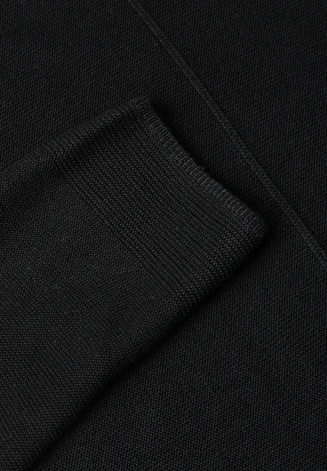 Gros plan sur un tissu noir finement tricoté, plié.
