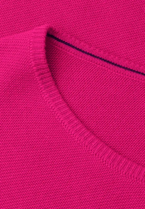 Nahaufnahme eines pinkfarbenen Strickpullovers mit Rundhalsausschnitt.