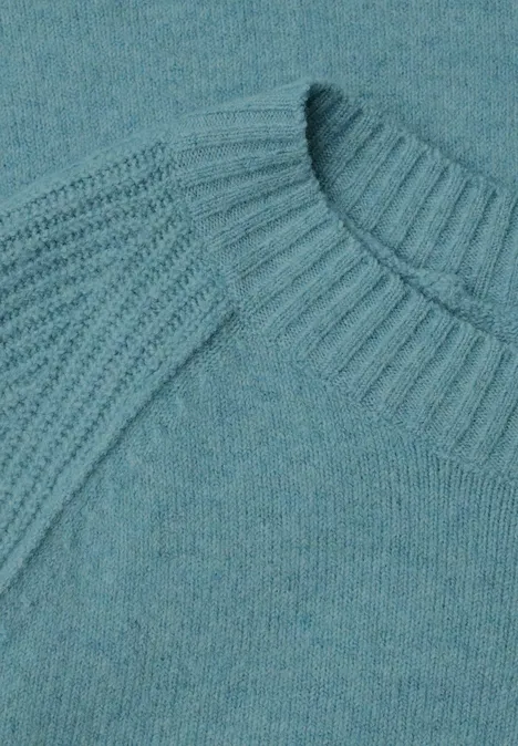Pull à col rond et mélange de textures multi lapis melange Gros plan d'un pull en maille turquoise avec un motif côtelé au col et aux épaules.