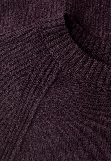 Nahaufnahme eines lila Strickpullovers mit geripptem Rundhalsausschnitt