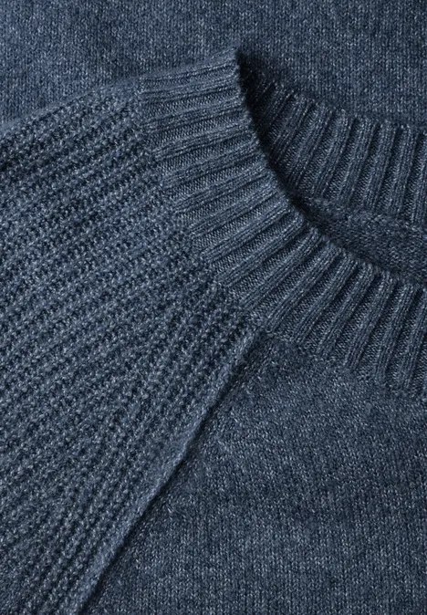 Nahaufnahme eines dunkelgrauen Strickpullovers mit Rundhalsausschnitt und Rippenstruktur.