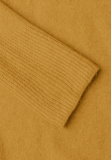 Pull col rond à textures contrastées golden honey melange Gros plan sur un pull en maille jaune moutarde montrant la manche et le corps du vêtement.
