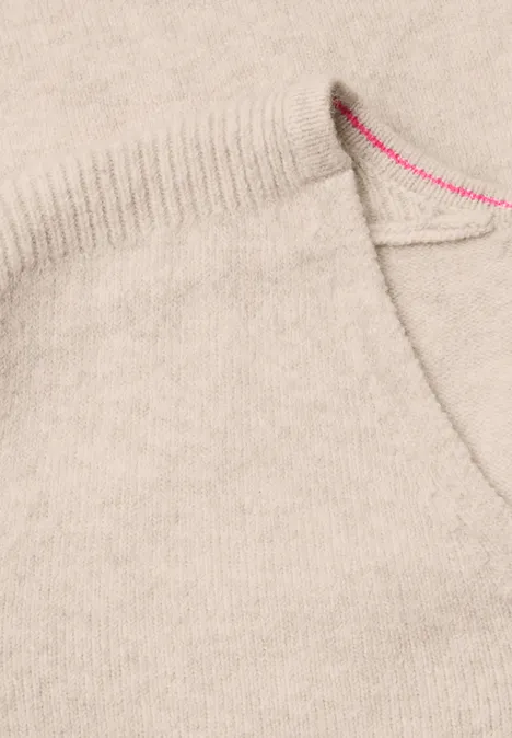 Nahaufnahme einer hellbeigen Wolltasche mit feiner Struktur und pinkem Stich am Saum.