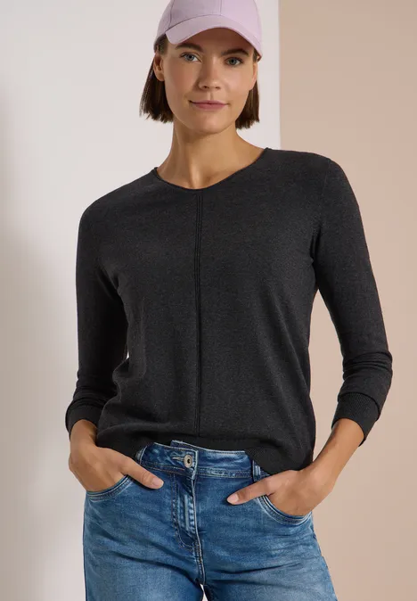 Pull couleur unie à col en V charcoal grey melange Femme en t-shirt à manches longues gris, jean et casquette, mains dans les poches, fond neutre.