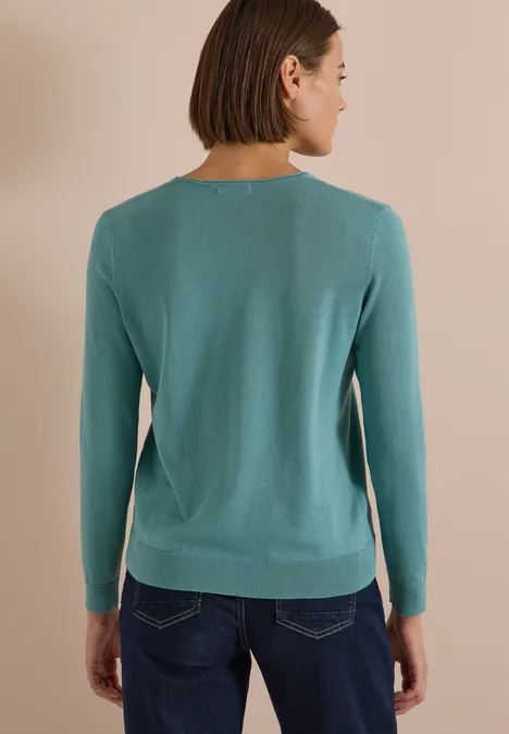 Basic Pullover mit V-Neck in Unifarbe mineral blue Rückenansicht einer Person in einem türkisfarbenen Langarmshirt und dunklen Jeans.