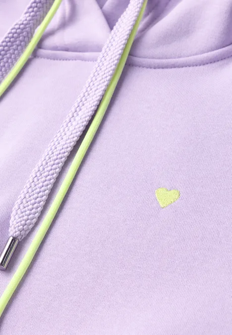 Sweat à capuche cool lilac Gros plan d'un sweat à capuche lavande avec cordons vert néon et petit logo cœur.