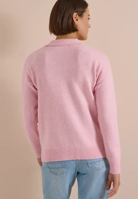 Trui met lange mouwen en polokraag mellow rose melange Persoon van achteren met een roze trui en blauwe jeans voor een beige achtergrond.
