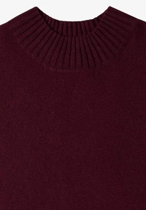 Dolman-trui met col red wine Ein schlichtes, dunkelrotes Strickshirt mit geripptem Rundhalsausschnitt, flach liegend fotografiert.