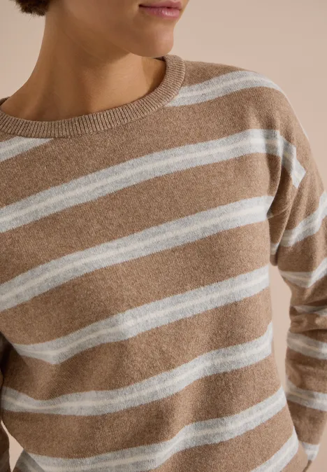 Beiger Pullover mit weißen Querstreifen, Damenoberteil, nur Oberkörper sichtbar.