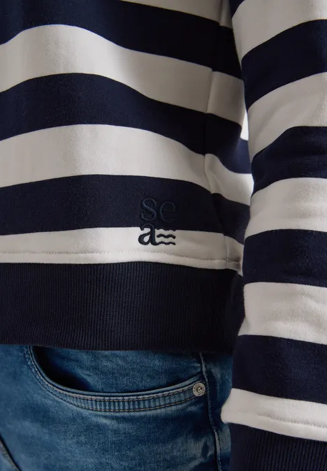 Sweatshirt mit Rundhals und Streifen urban dark blue Nahaufnahme eines dunkelblau-weiß gestreiften Pullovers über Jeans.