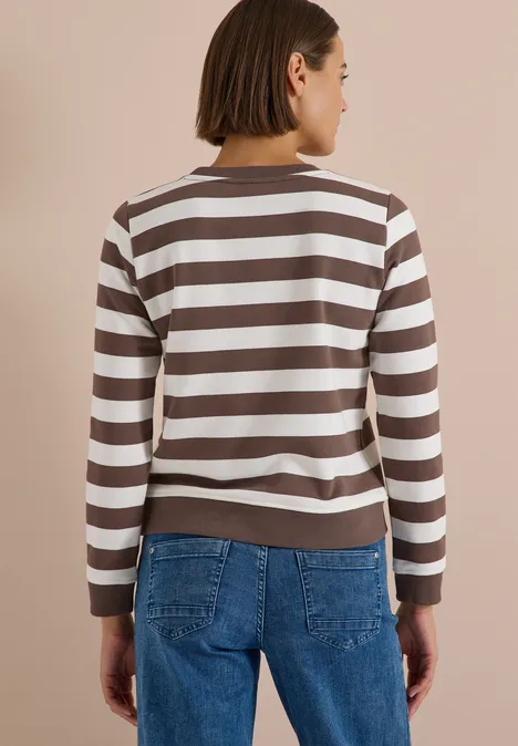 Sweatshirt mit Rundhals und Streifen urban taupe Frau von hinten in gestreiftem Braun-Weiß-Pullover und blauen Jeans, kurzhaarig.