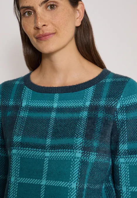 Langarm Pullover mit Karomuster deep petrol blue Frau mit dunklem Haar und Sommersprossen trägt einen karierten Teal-Schwarz-Pullover mit Rundhalsausschnitt.