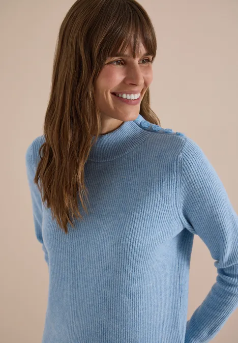 Pullover mit Struktur und Knopfdetail easy blue melange Frau mit braunen Haaren trägt hellblauen Rippstrick-Pullover mit hohem Kragen und Schulterknöpfen, sie lächelt.